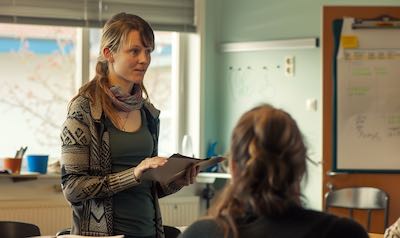 sprachtrainerin gibt Sprachunterricht an einer Volkshochschule